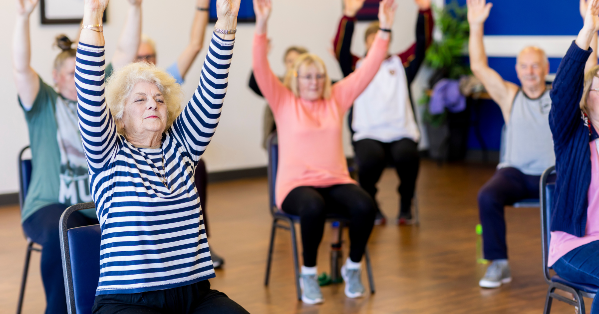 senior citizens participating in a low-impact chair aerobics class