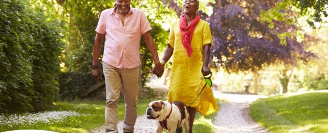 Walks, like this older couple and their dog are engaged in, are great activities for seniors in the springtime.