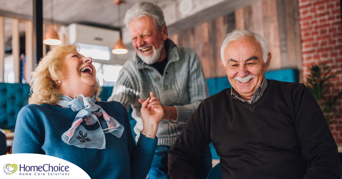 Older adults laugh and enjoy each other’s company representing how socialization can help seniors.