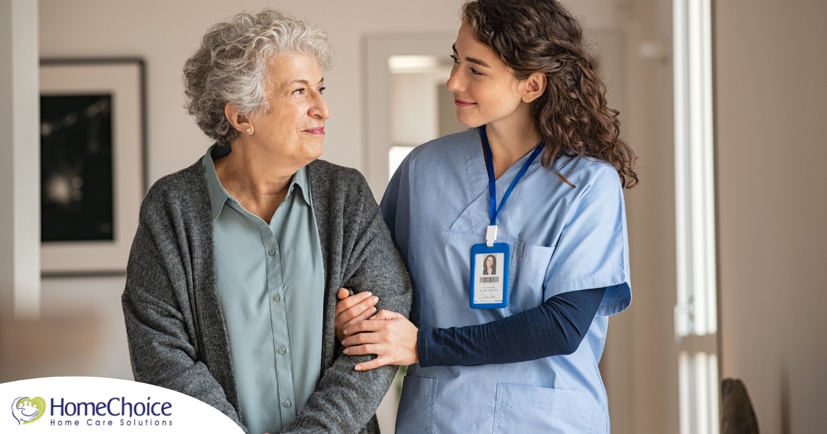 A caregiver and client smile at each other as the caregiver helps the client, representing emotional intelligence in caregiving.