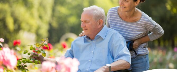 A caregiver takes a senior outside to visit a garden, highlighting one idea for senior activities.