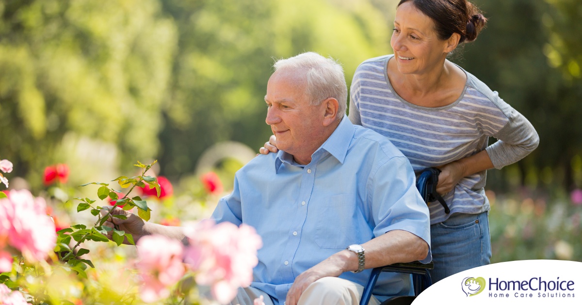 A caregiver takes a senior outside to visit a garden, highlighting one idea for senior activities.