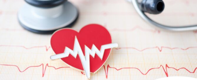 A heart symbol with an electrocardiogram line, an electrocardiogram sheet, and a stethoscope represents heart health.